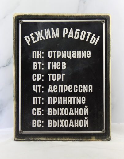 Демотиватор на состаренной доске с расписанием недели: ПН – отрицание, ВТ – гнев, СР – торг, ЧТ – депрессия, ПТ – принятие, СБ – выходной, ВС – выходной. Винтажный дизайн, чёрные винты по углам