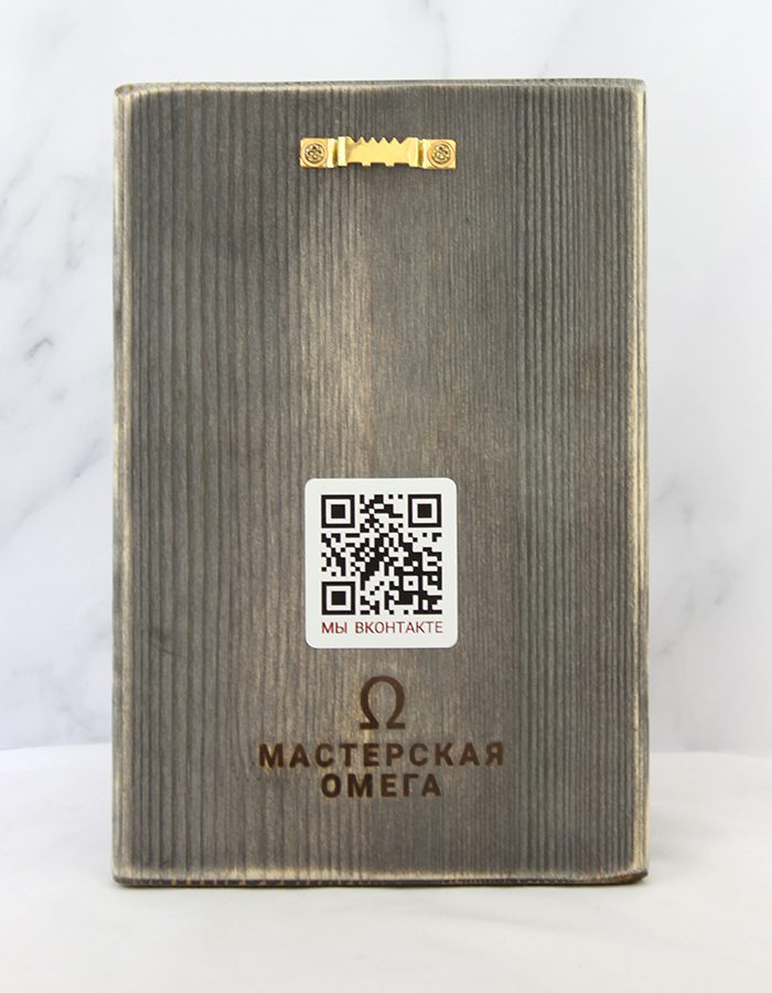 Старинная пасхальная открытка на состаренной доске с изображением мальчика и девочки в русских костюмах (кокошник, кафтан) за пасхальным столом с куличом и пасхой, надпись «Христос воскрес» с вензелями. Задник