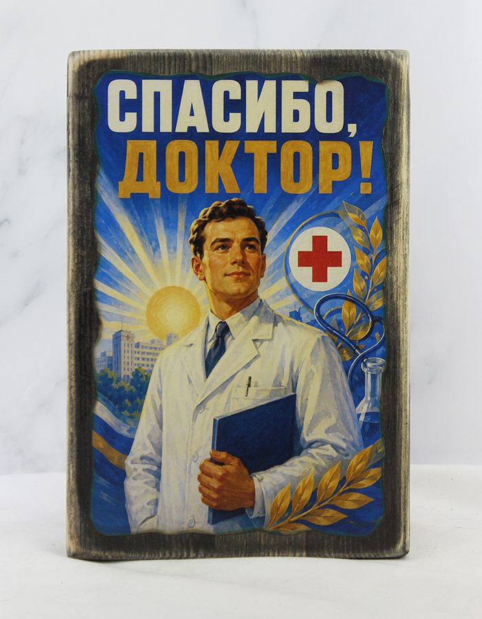 Табличка «Спасибо доктор» с изображением молодого врача с книгой в руках, лавровыми ветками, солнцем и жилым домом на состаренной доске